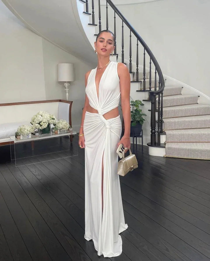 White V-neck maxi dress with thigh-high slit in soft, flowy fabric. Trendy and chic design, perfect for a summer day out.