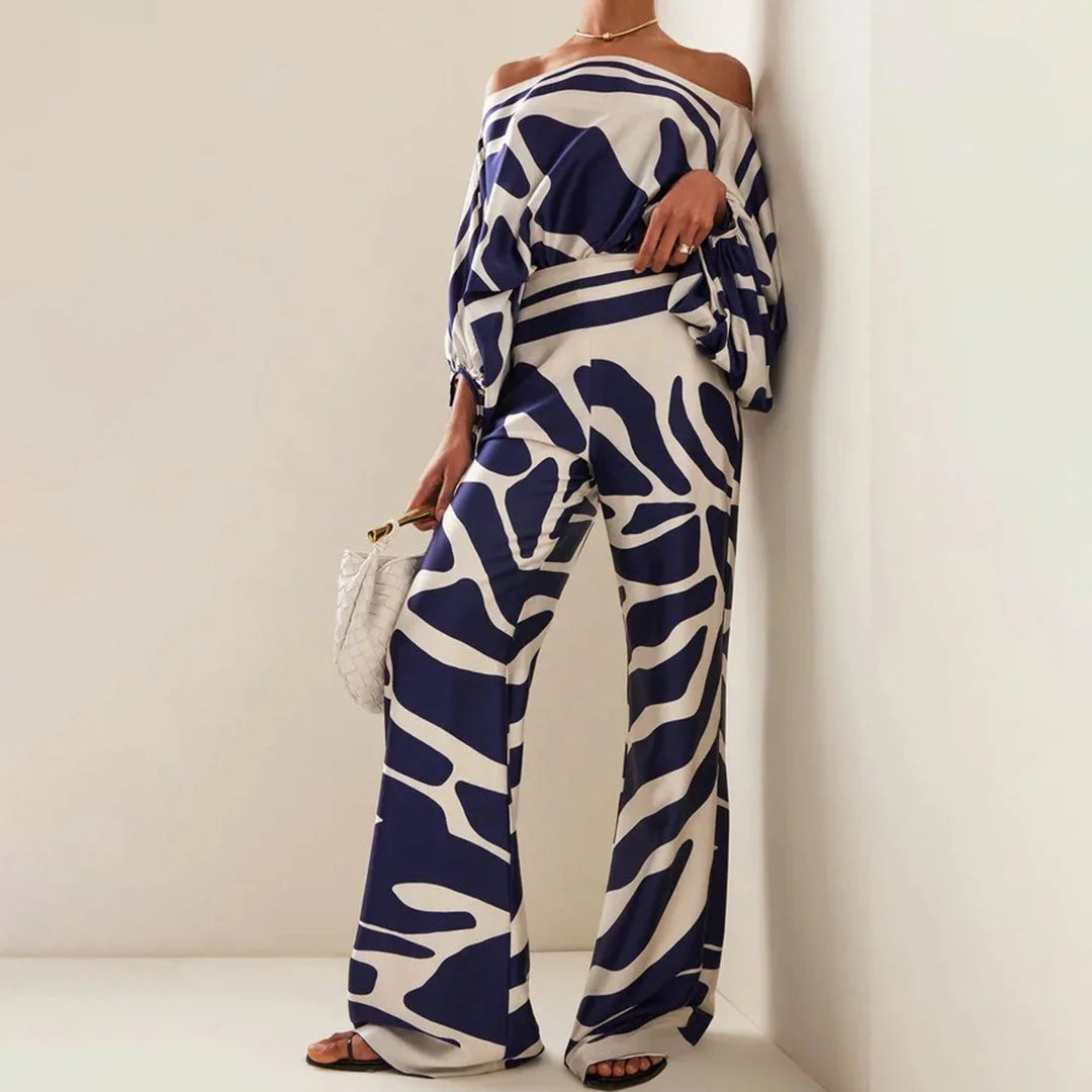 "Two-piece set featuring off-shoulder blouse and straight pants in a soft, breathable fabric with a relaxed and stylish…