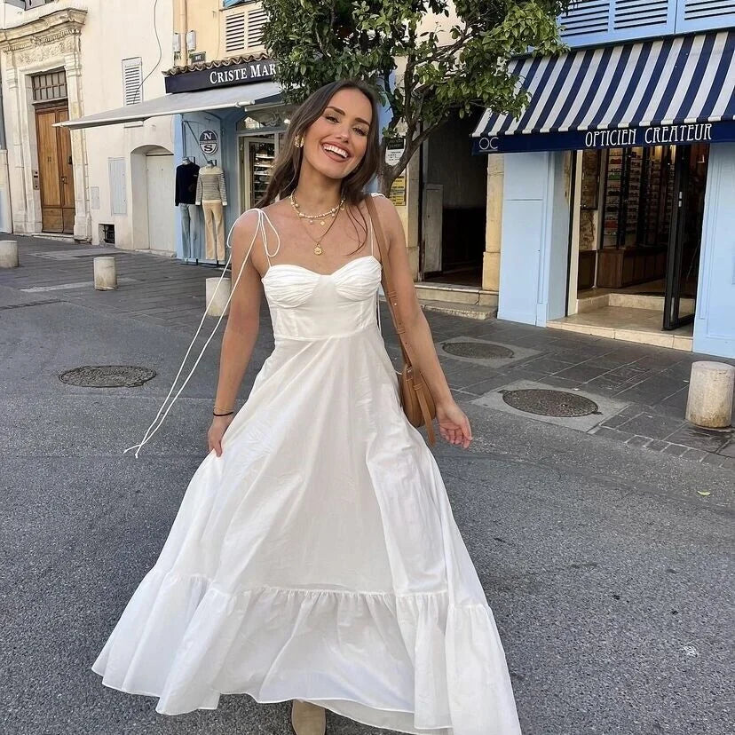 White maxi dress with ruched bodice, featuring a flowy silhouette and soft fabric perfect for summer outings or beach…