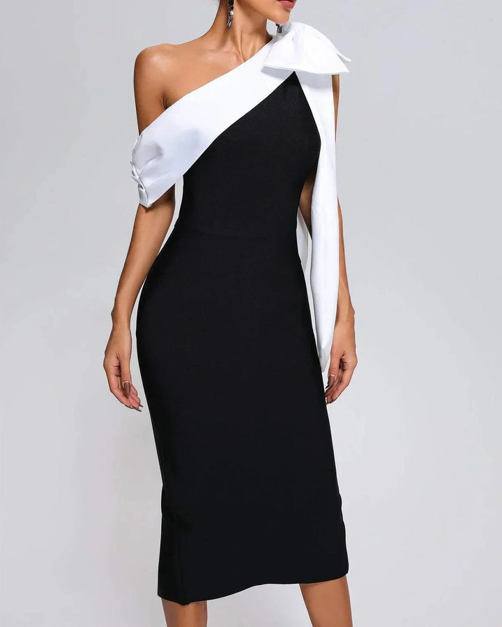 Black and white midi dress with asymmetrical design, made with soft and breathable fabric, perfect for a chic and modern…