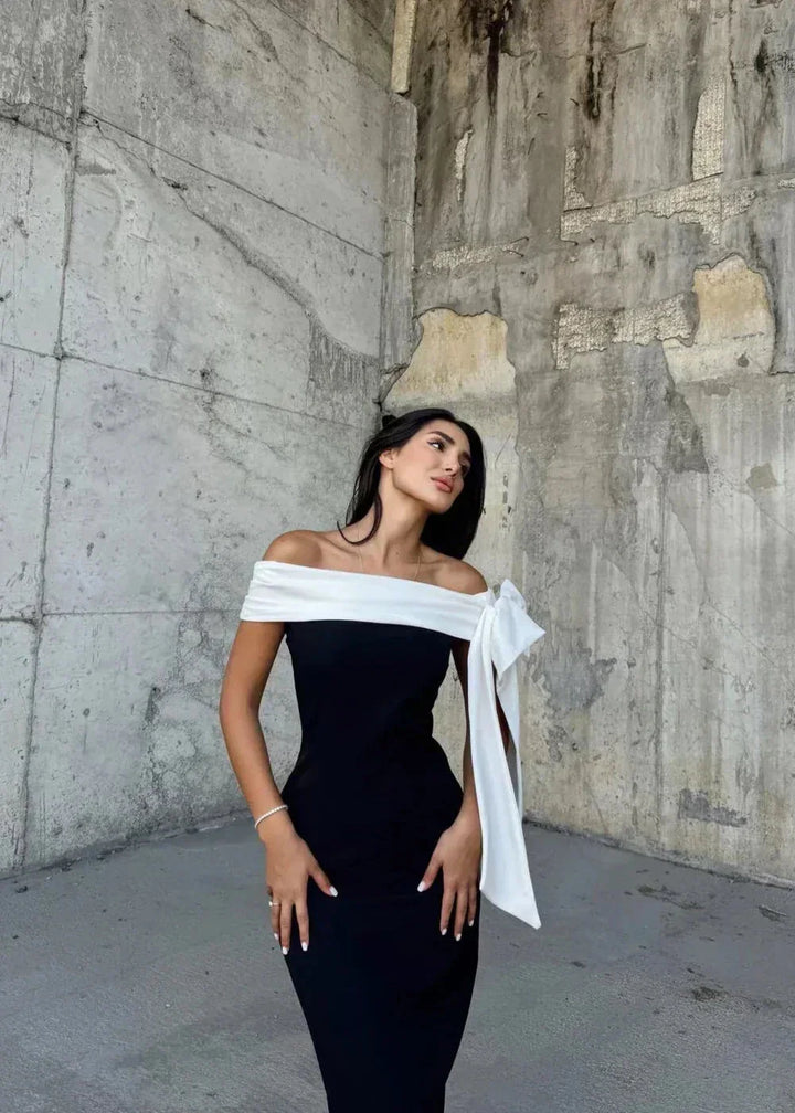 "Black and white midi dress featuring asymmetrical design, made of high-quality fabric, perfect for a modern and stylish…