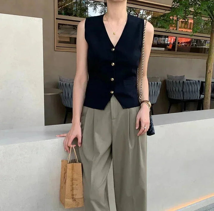 "Sleek black sleeveless vest with button details, made of breathable and comfortable fabric, perfect for adding a chic touch…