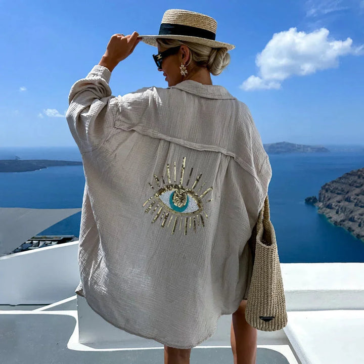Khaki oversized blouse with eye motif design for women, made of lightweight and breezy fabric for a comfortable and stylish…