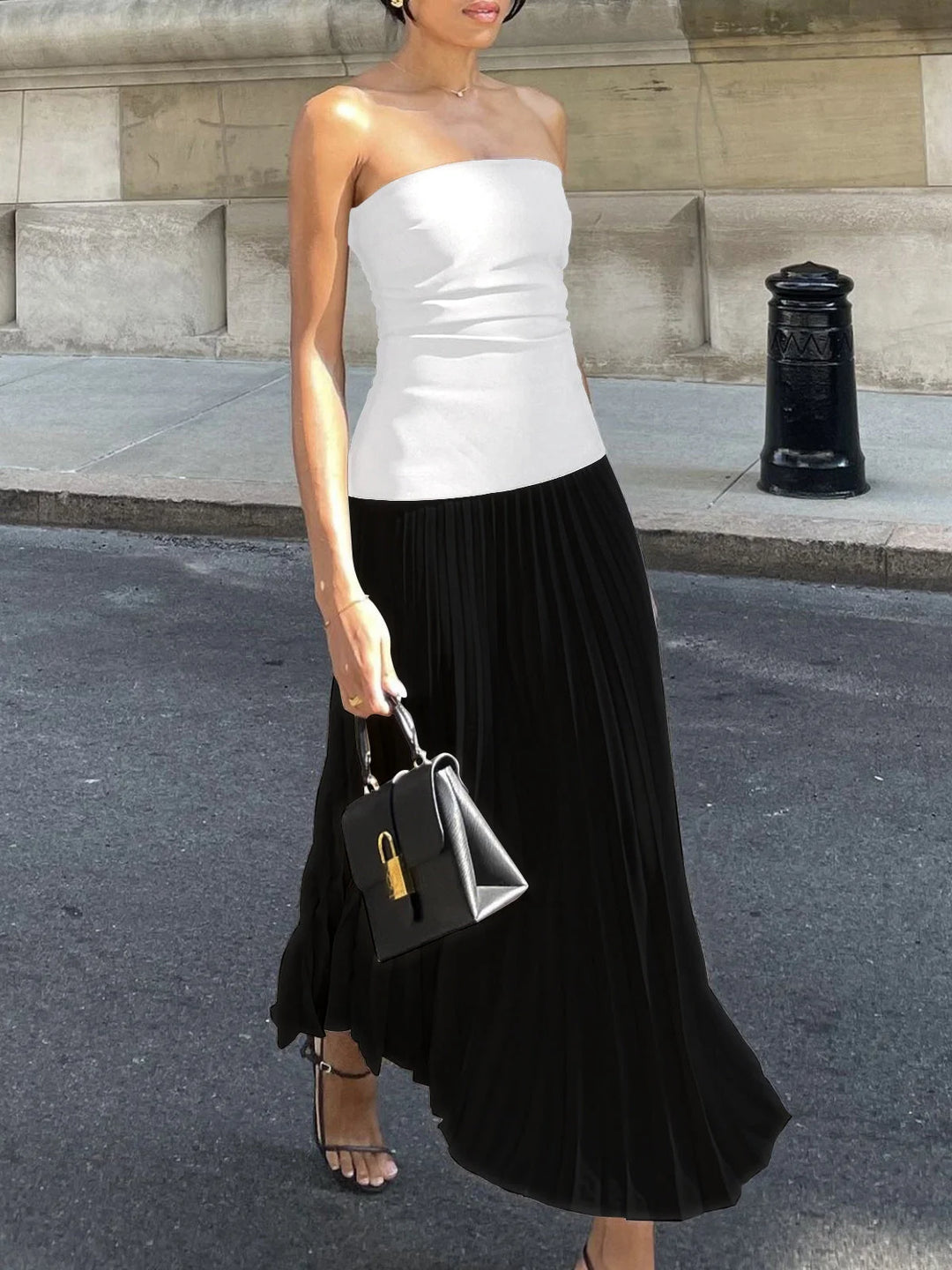 Black strapless pleated maxi dress with two-tone design, perfect for any occasion. Made with high-quality fabric for a…