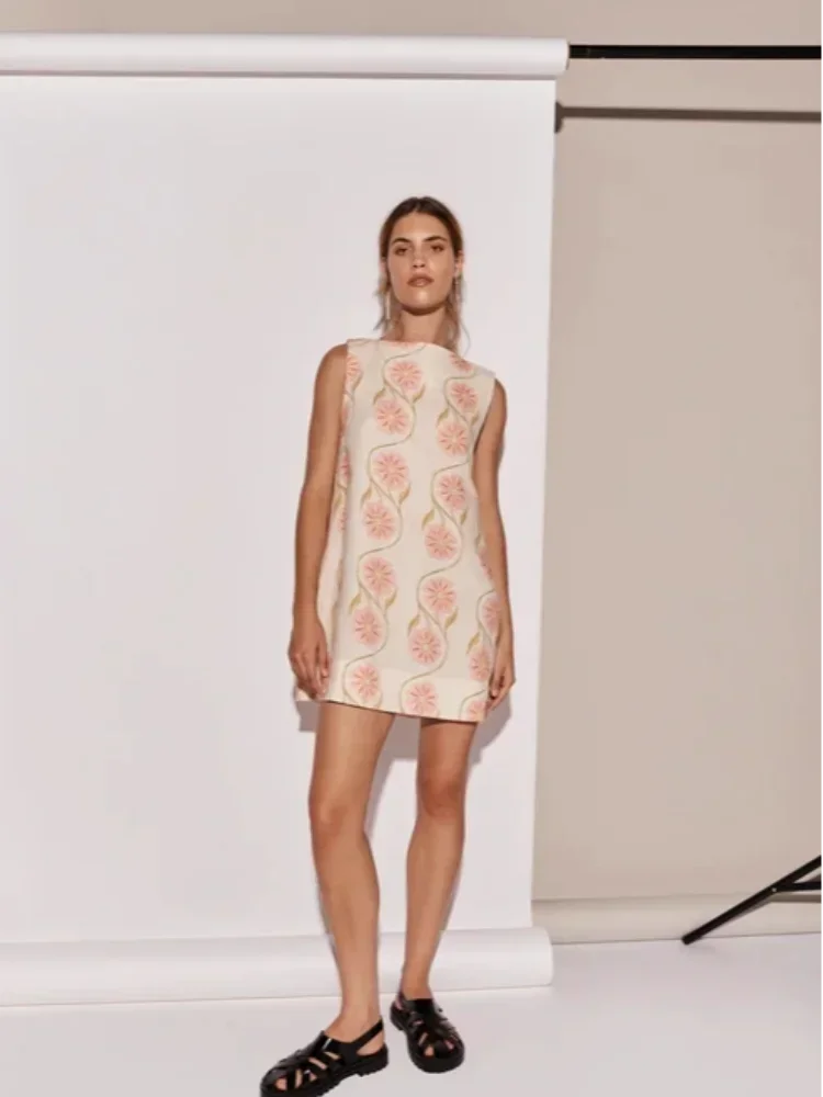 Pink floral A-Line sleeveless dress in Justine, showcasing a vibrant floral pattern on a lightweight fabric with a…