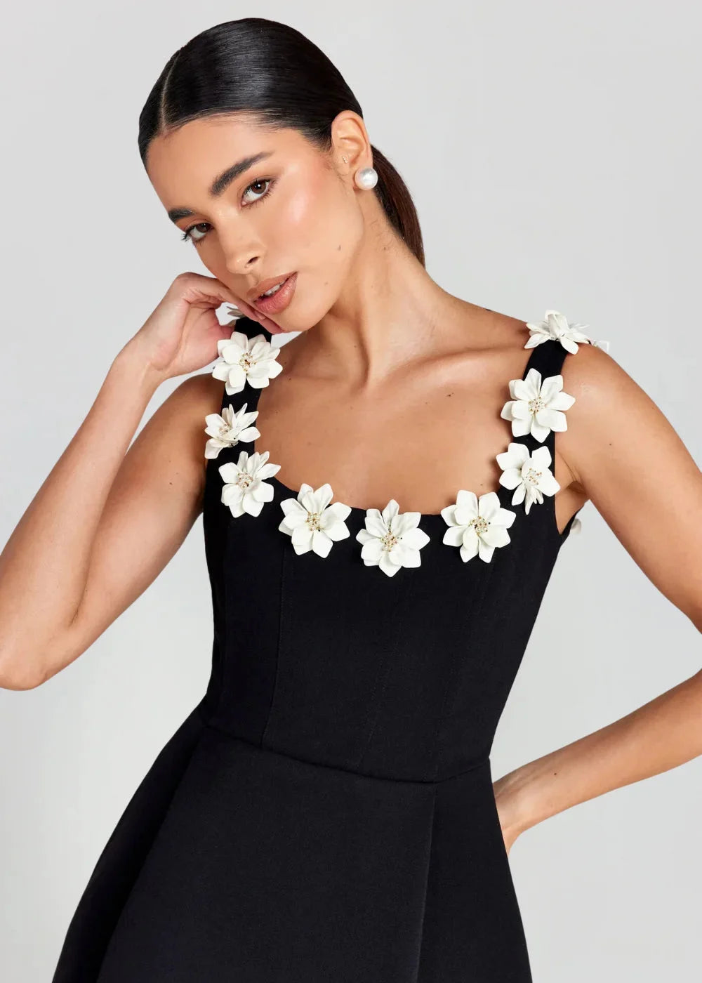 Black mini dress with white floral embroidery on bodice, made of soft and textured fabric. Perfect for a classy look at any…