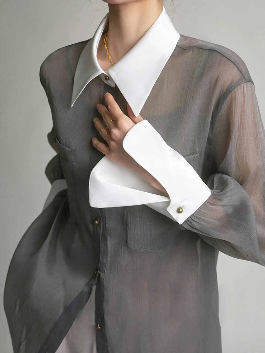 Sheer white button-up blouse with stylish collar, perfect for a chic and sophisticated look.
