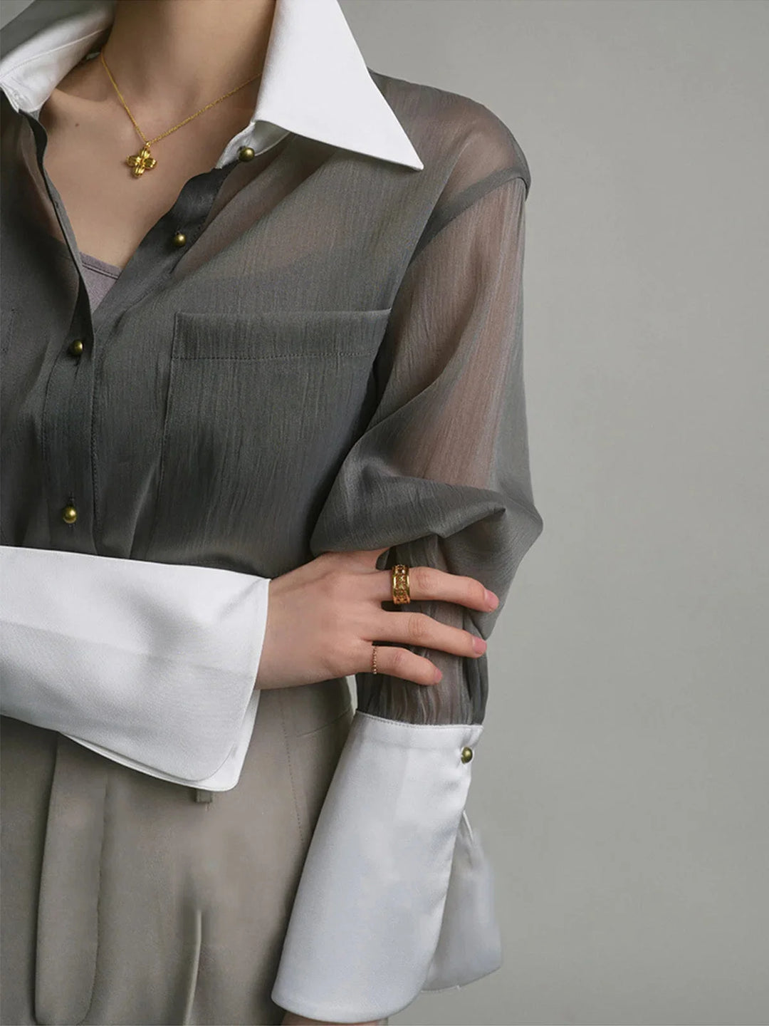 Sheer button-up blouse with chic collar in soft pastel pink, perfect for casual or formal wear.