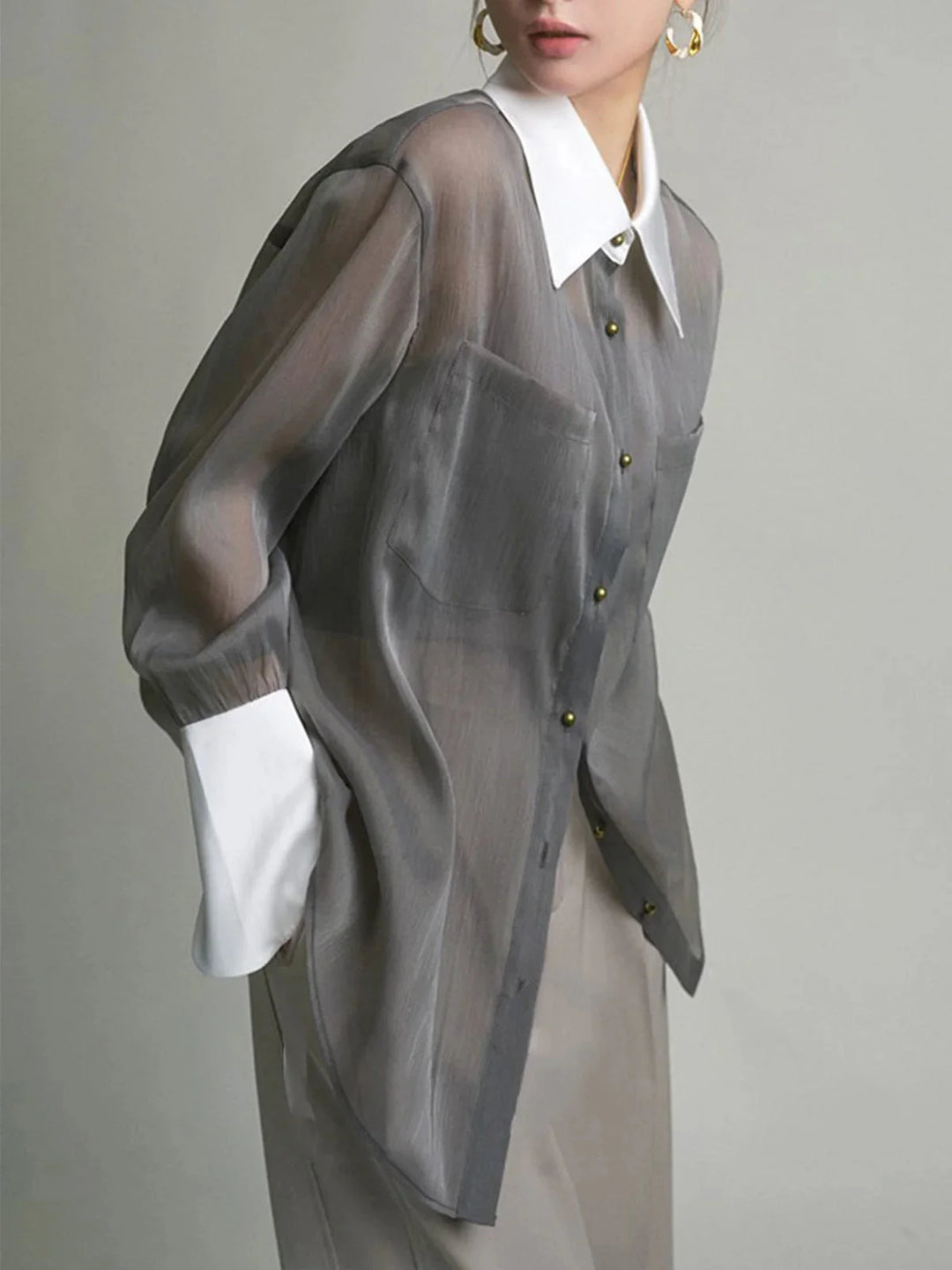 "Grey sheer button-up blouse with stylish collar, perfect for elevated casual looks. Light chiffon material with a…