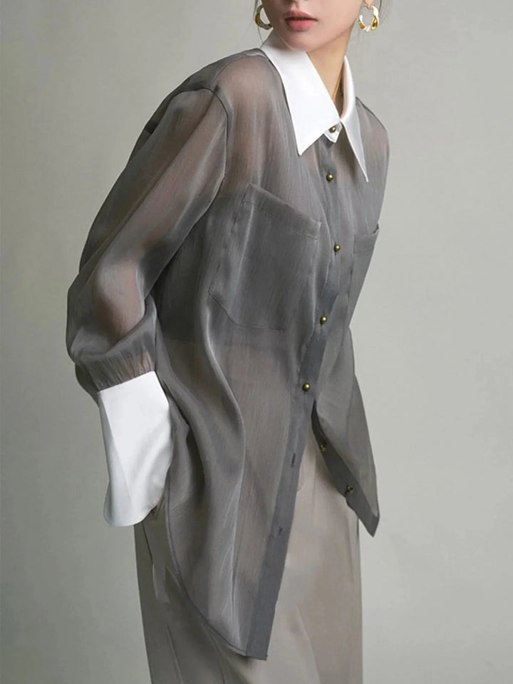 "Grey sheer button-up blouse with stylish collar, perfect for elevated casual looks. Light chiffon material with a…