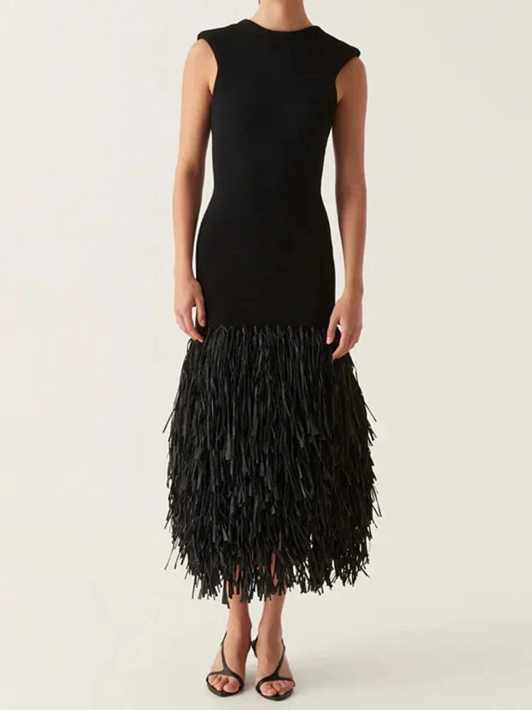 Black sleeveless midi dress with intricate fringe detail cascading down the side, perfect for a chic and sophisticated look.
