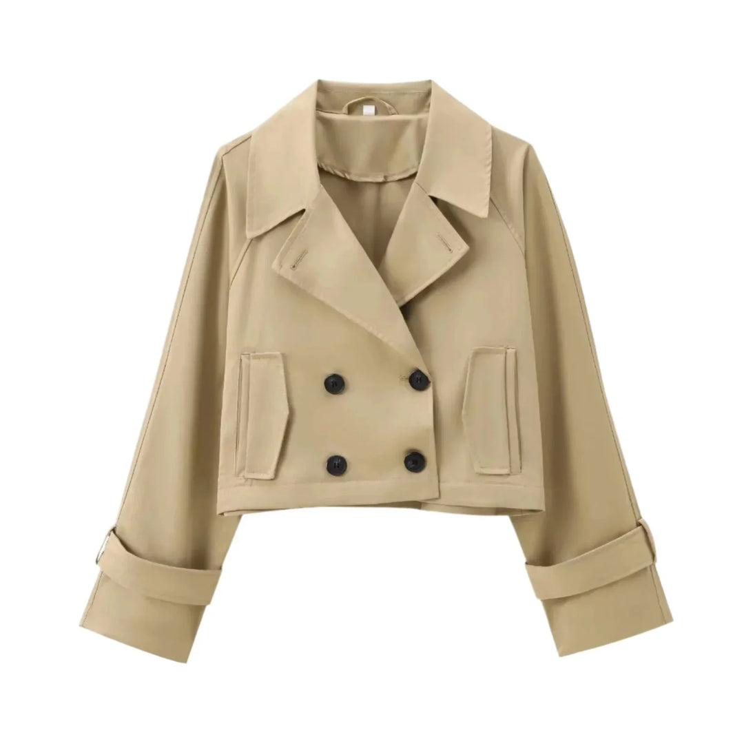 Stylish cropped trenchcoat in neutral hue featuring button detailing and structured silhouette, perfect for layering in…