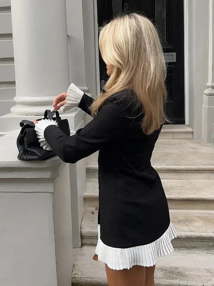 "Black blazer dress with white pleated hem, modern and stylish design made from high-quality material."