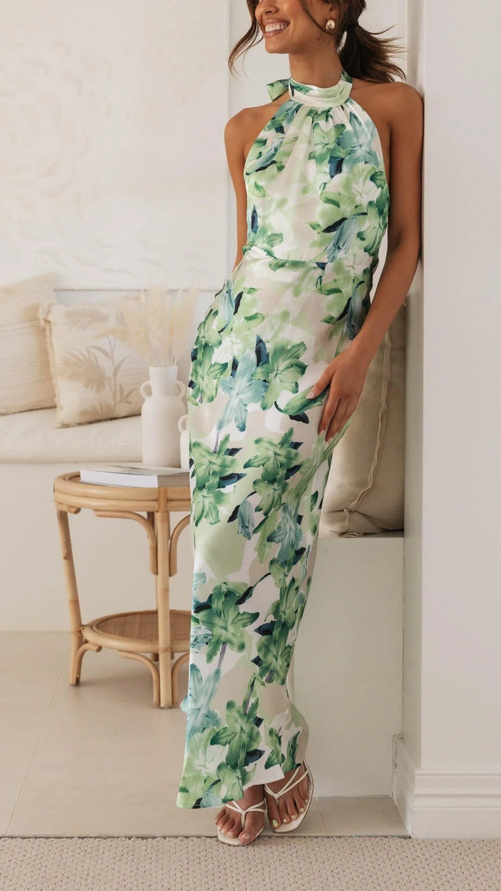 Green halter maxi dress with a bold floral pattern. Made from soft, flowing fabric perfect for a breezy summer day.