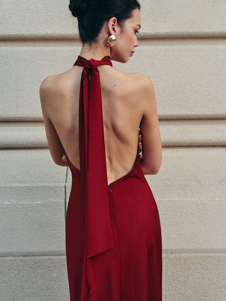 Red satin halter dress with trailing bow, elegant design with a flattering silhouette suitable for special occasions.