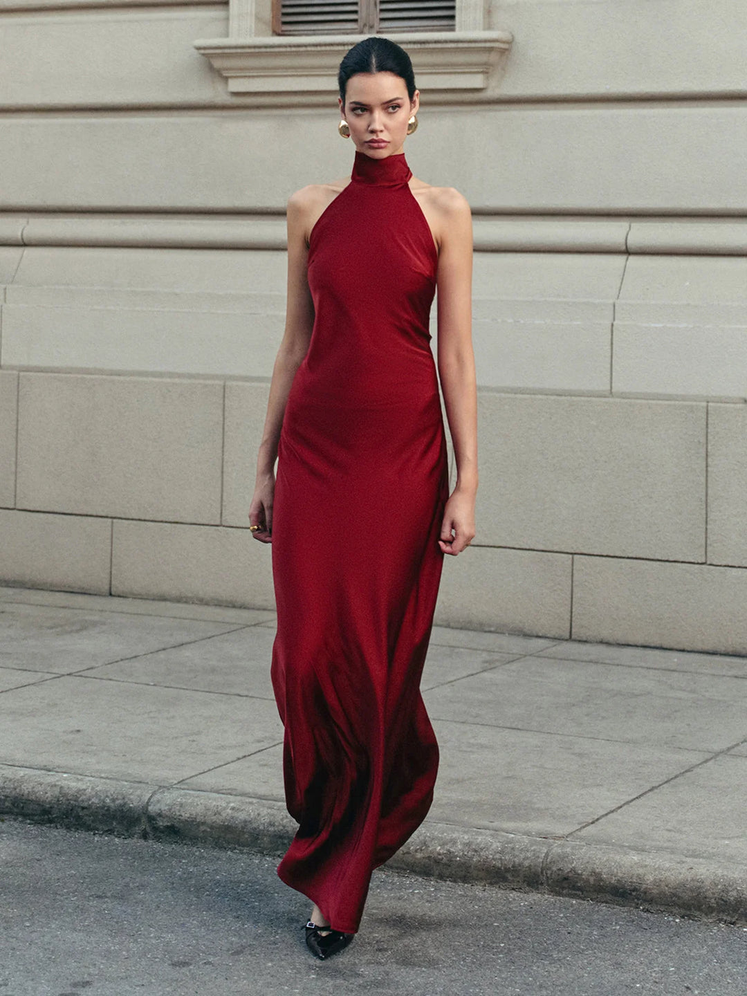 Red satin halter dress with a trailing bow in a vibrant red color, ideal for special occasions and events.