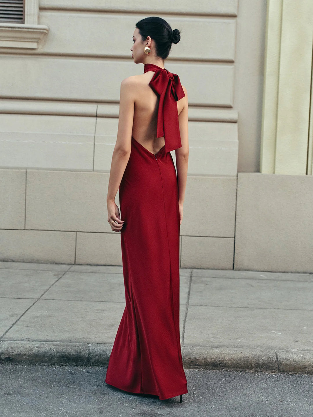 Red satin halter dress with a trailing bow, a sleek and elegant design perfect for a special occasion.