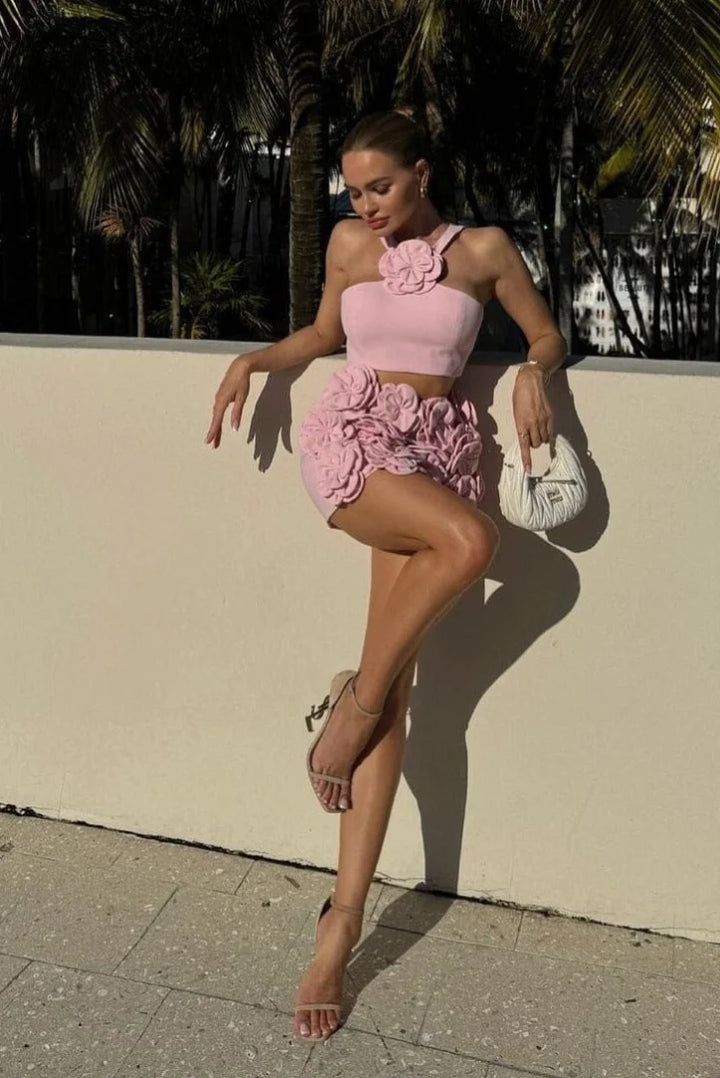 Pink halter top and shorts set with floral applique detailing. Feminine design perfect for summer days.