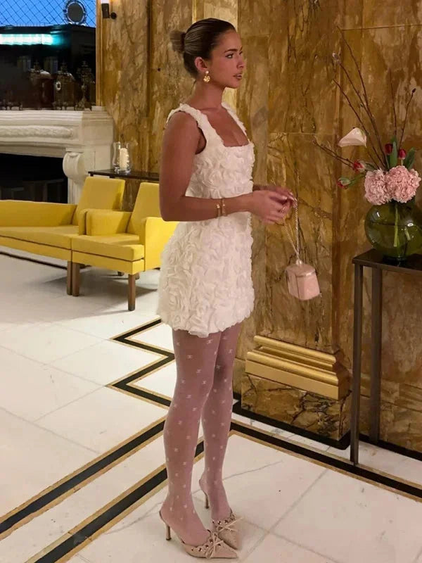 Floral textured mini dress in pastel hues with thin straps, perfect for a casual yet stylish summer look.