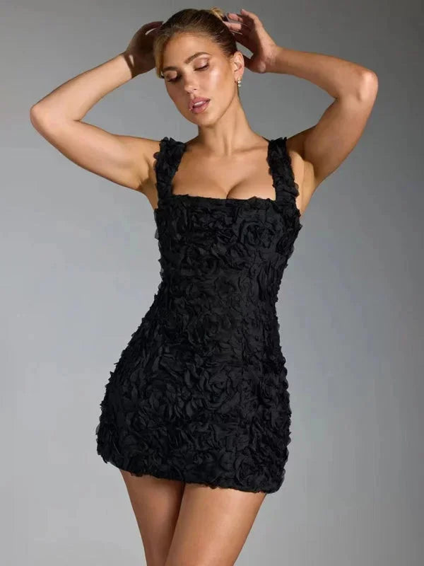 Black mini dress with floral texture and straps, perfect for casual or formal wear.
