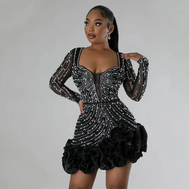 Black mini dress featuring ruffles and embellishments. Crafted with lightweight fabric.