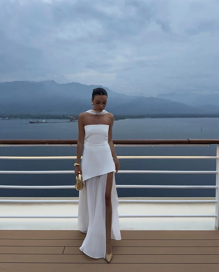 "Black asymmetrical layered maxi dress with a draped neckline and split hem, made from a lightweight and breathable fabric."