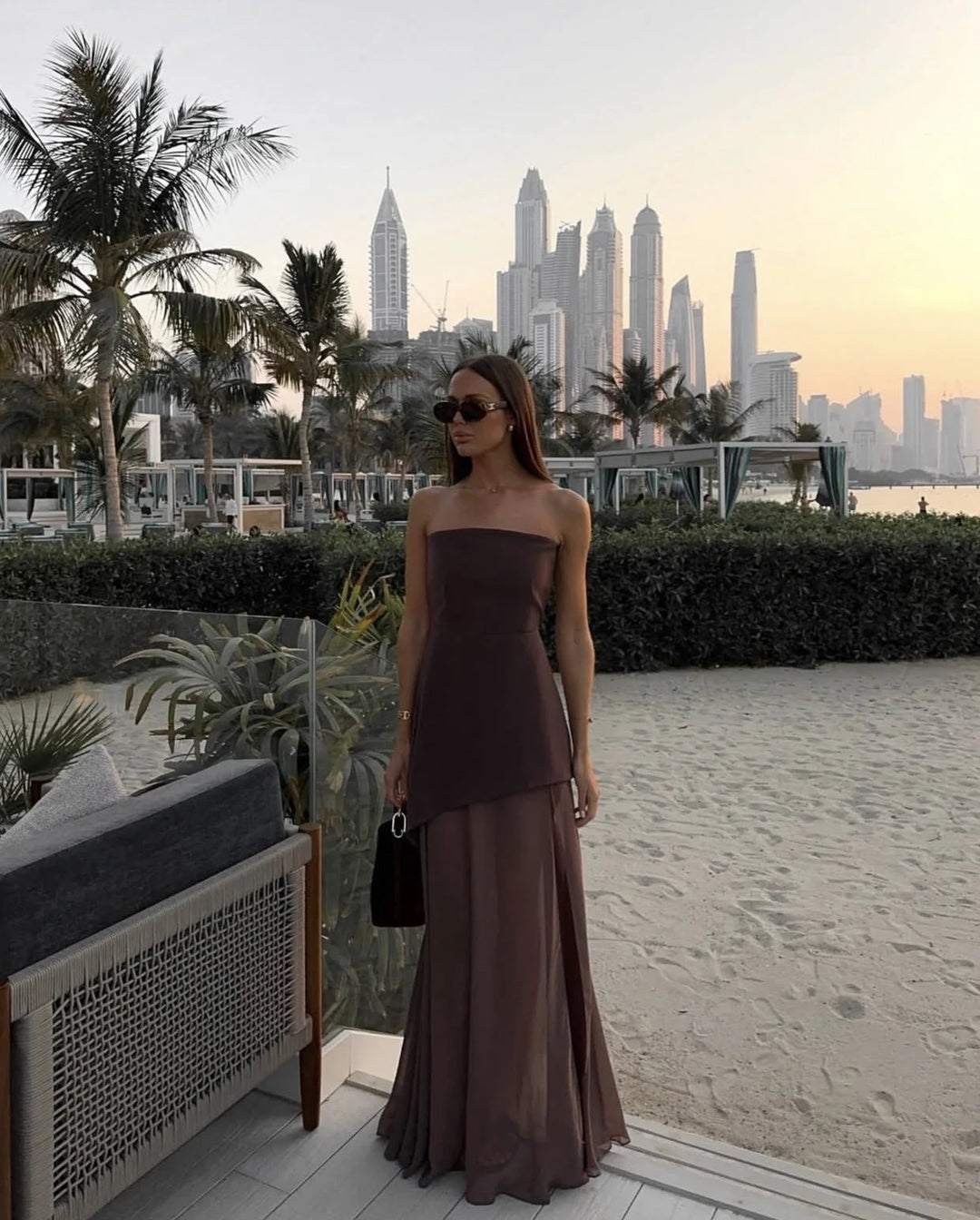 Brown asymmetrical layered maxi dress with a flowing design and V-neckline, made from lightweight and breathable fabric.