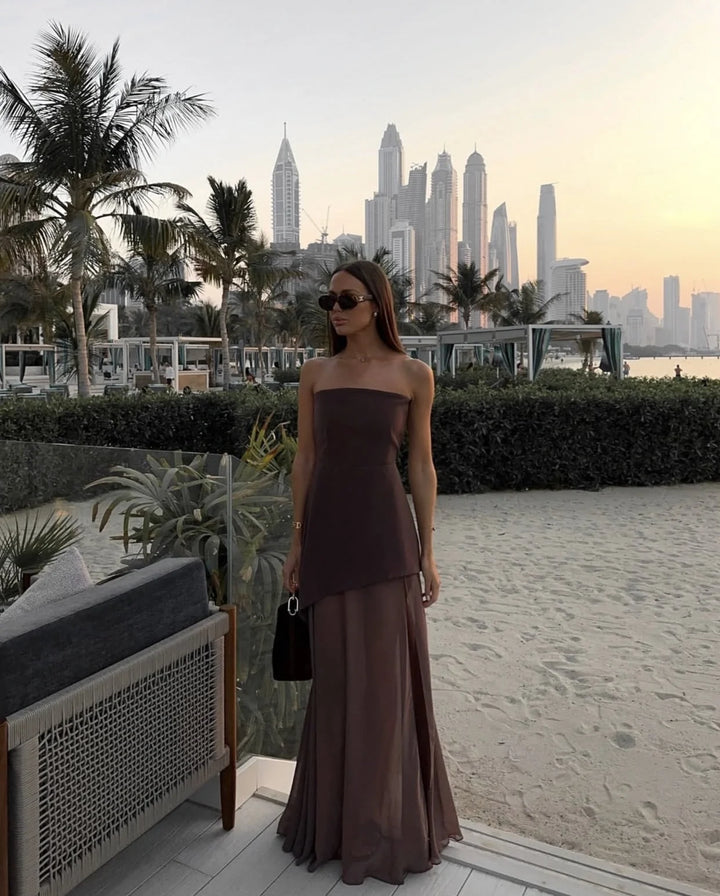 Brown asymmetrical layered maxi dress with a flowing design and V-neckline, made from lightweight and breathable fabric.