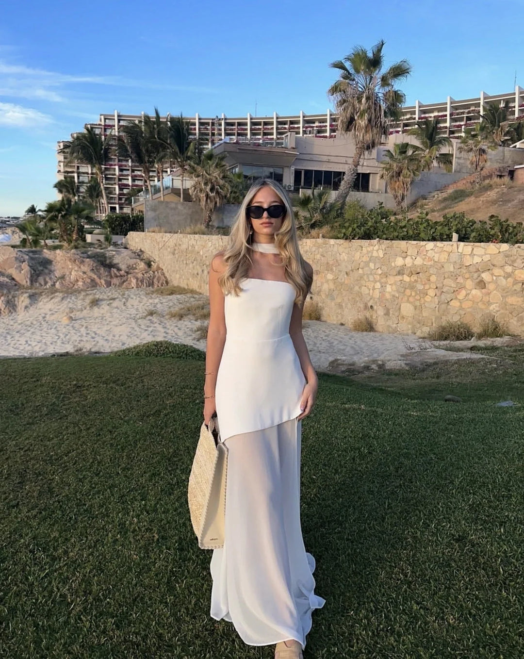 "White asymmetrical layered maxi dress in soft cotton blend, with a modern design and delicate pleating details."