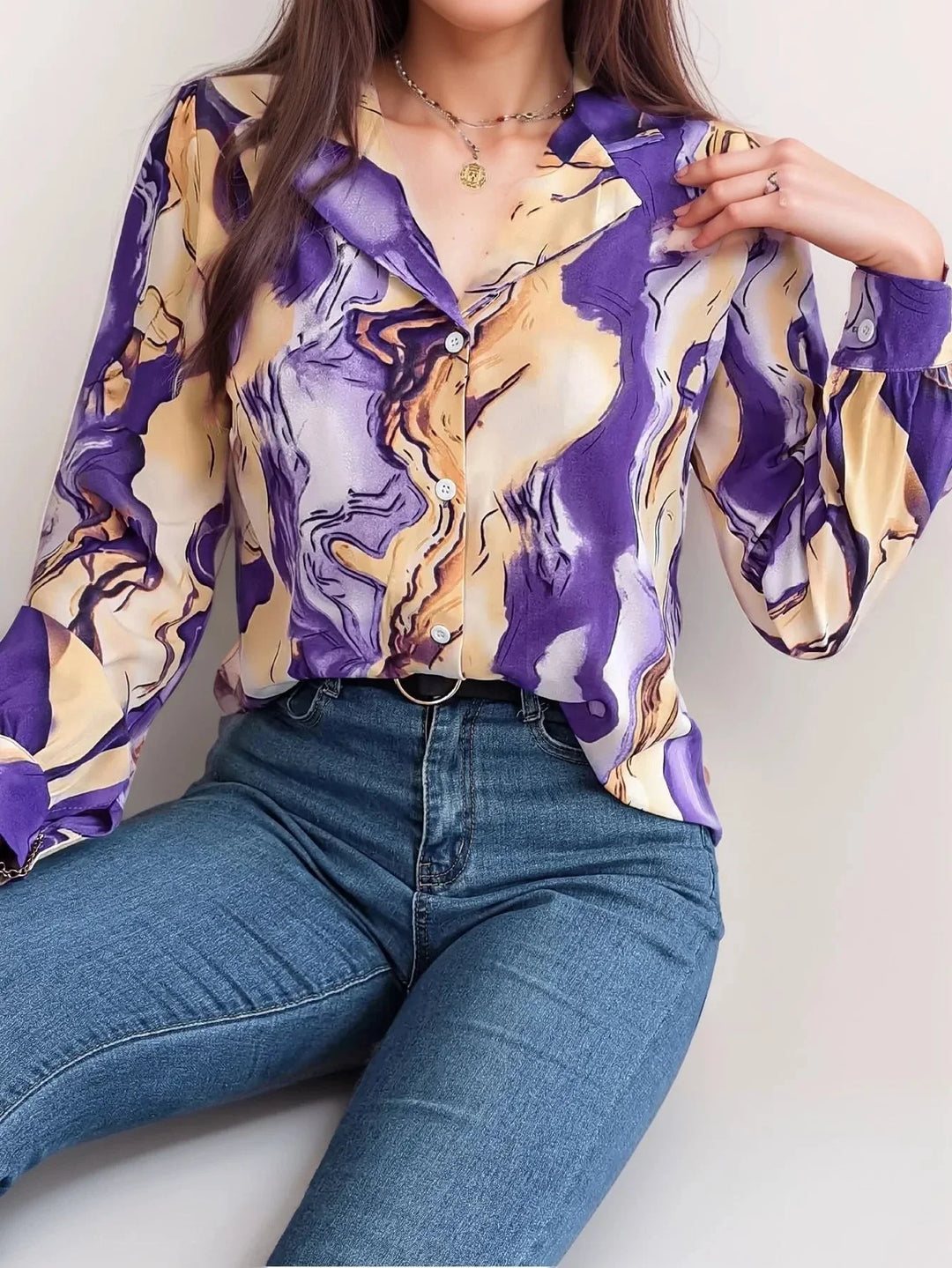 Purple satin top with button-up front featuring artistic design details.