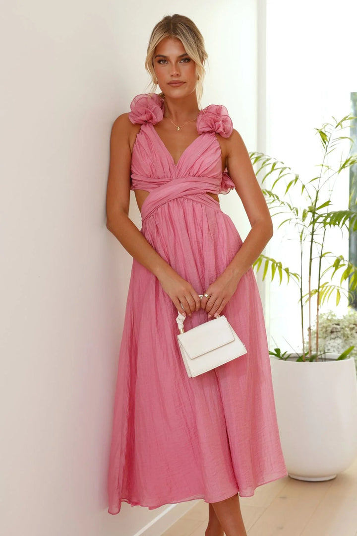 Pink midi dress with twisted bust, ruffles. Soft, flowing fabric drapes elegantly. Perfect for a stylish and chic look.