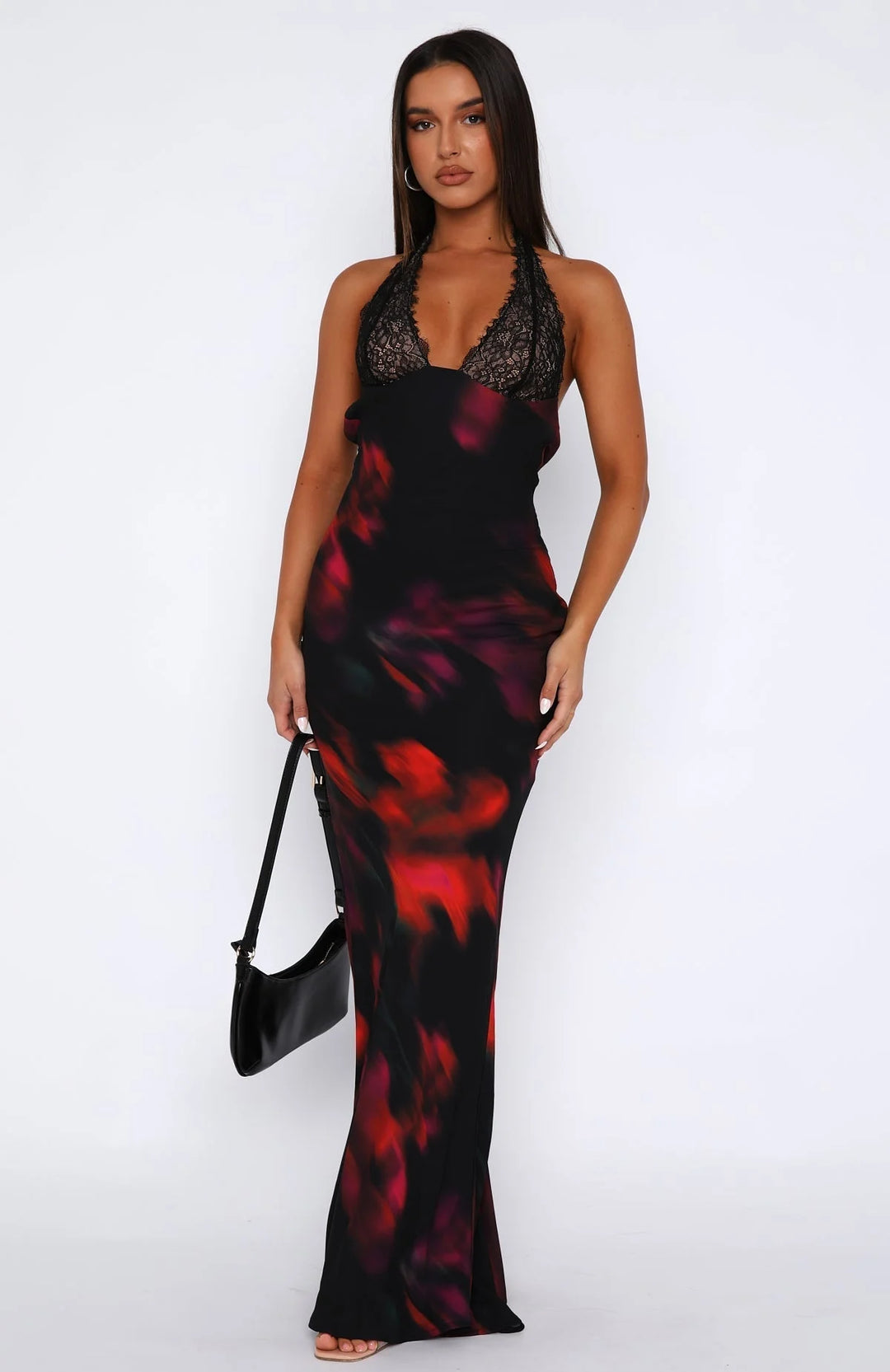 Black halter neck dress with delicate lace overlay on the bodice and a flowing skirt, perfect for a chic evening out.