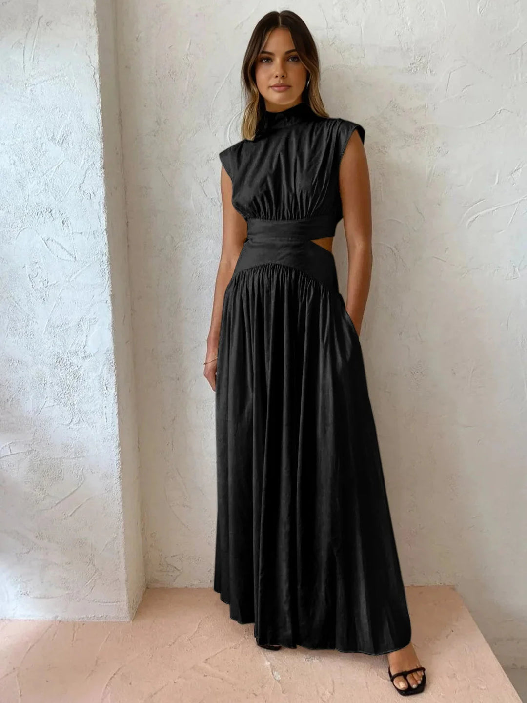 "Sleek black sleeveless dress with high mock neck and edgy cutouts, perfect for a chic and modern look."