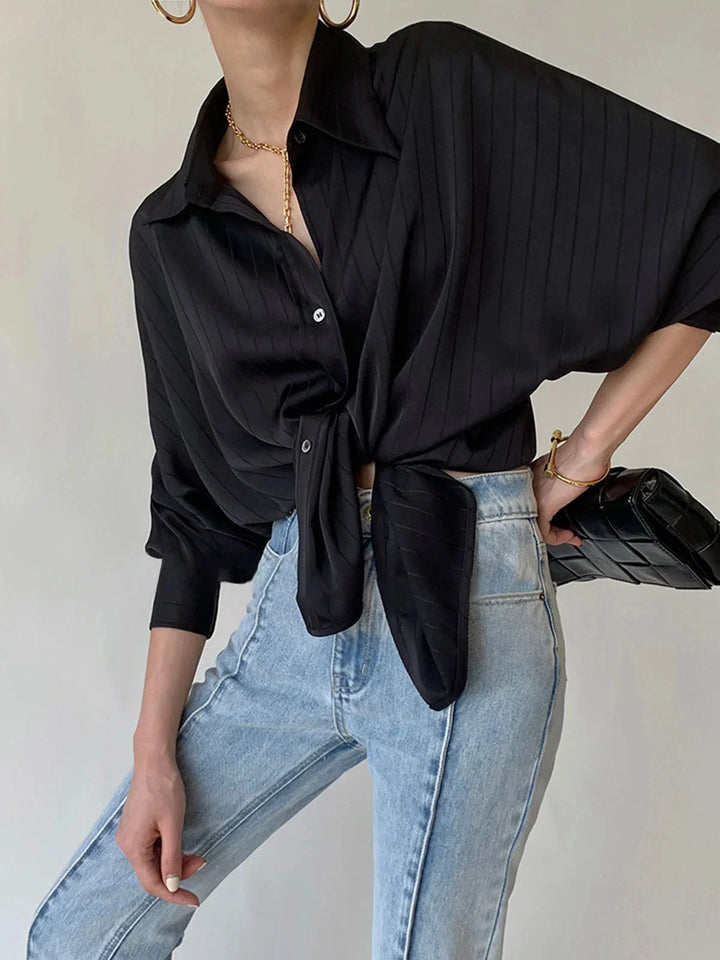 Black button-up shirt with gold accents, modern design.
