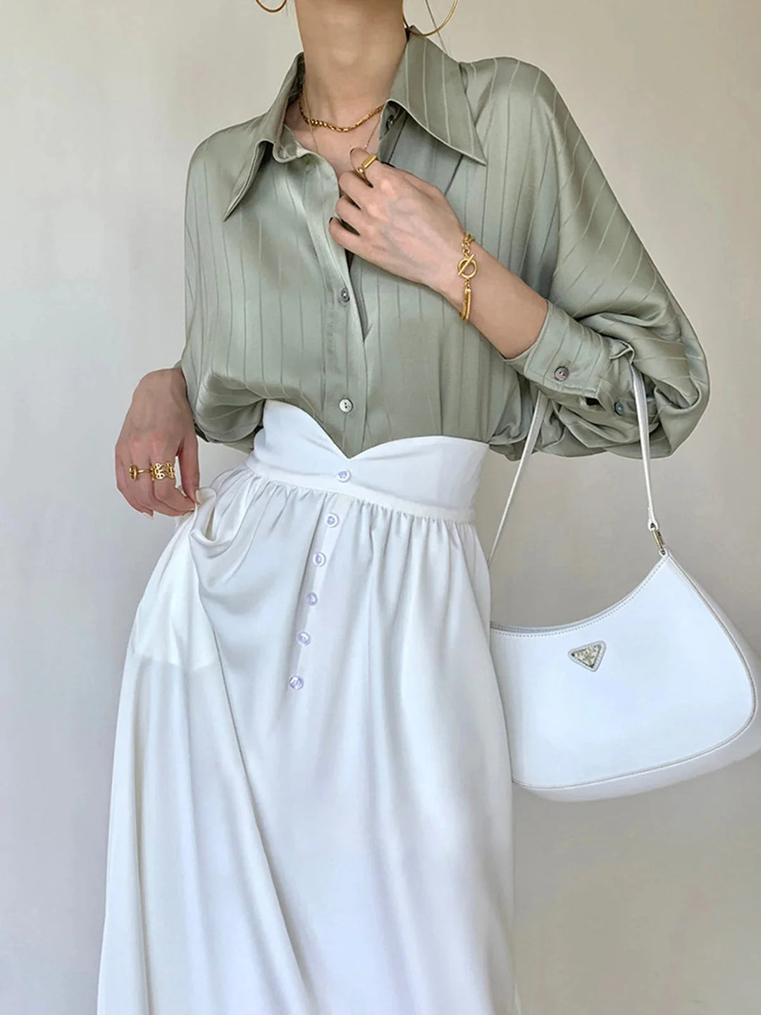 "Button-up shirt in sleek black with gold accents, perfect for a sophisticated look."