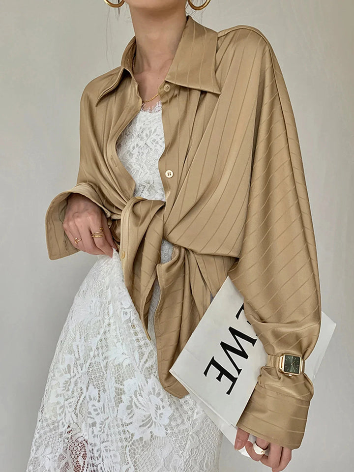 Sleek black button-up shirt with gold accents, perfect for adding a touch of elegance to your outfit.