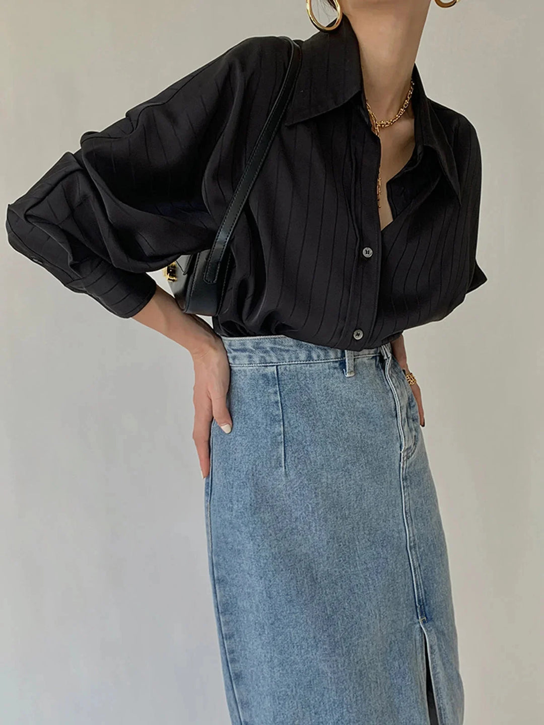 Black button-up shirt with gold accents and a sleek design by Laylani.