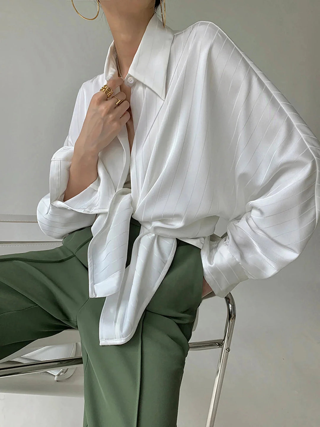 White Laylani button-up shirt with gold accents, elegantly tailored in a sleek design.