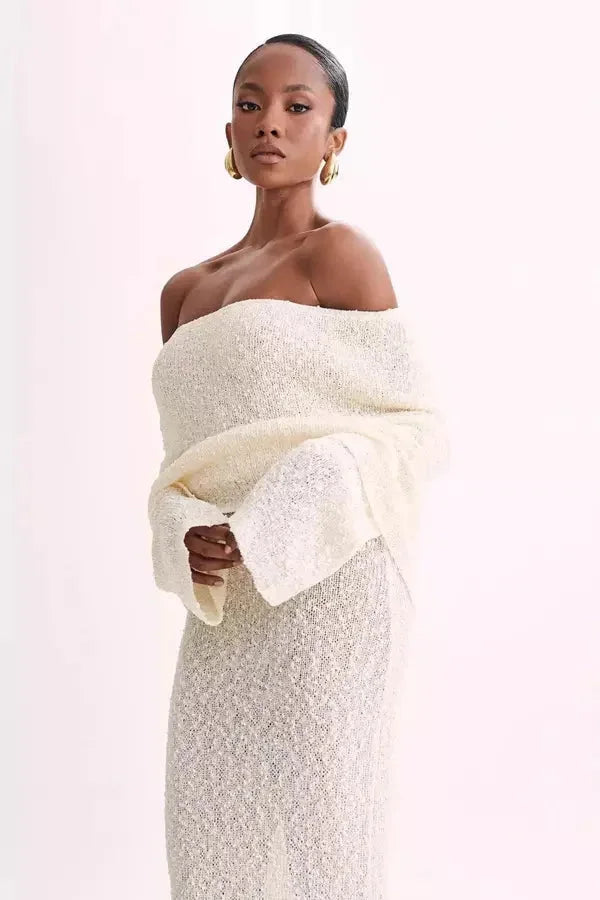 Off-shoulder white dress with elegant sleeves, perfect for special occasions.
