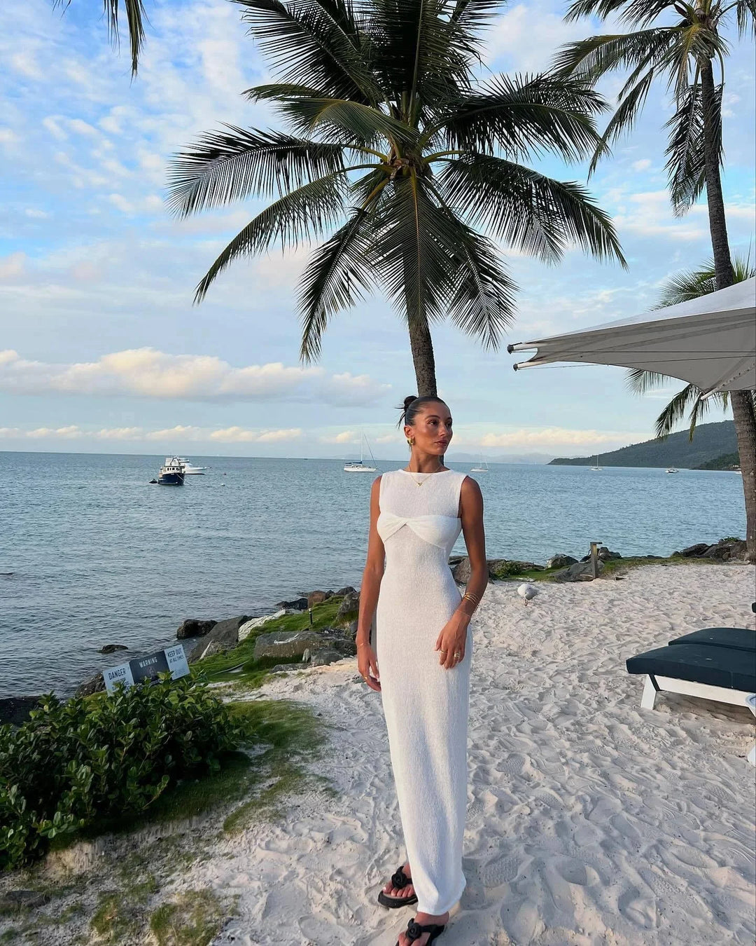Sleeveless white maxi dress with twist detail, perfect for sunny days. Made of lightweight, comfortable fabric for a casual…