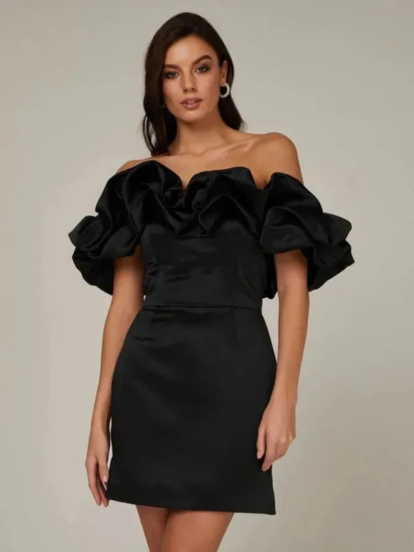 Black off-shoulder dress with ruffles, sleek design, and fitted silhouette. Ideal for a chic and elegant look on special…