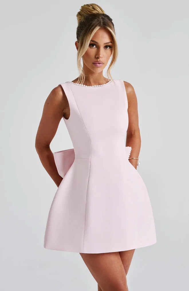 "Black backless dress with elegant pearl accents perfect for special occasions."