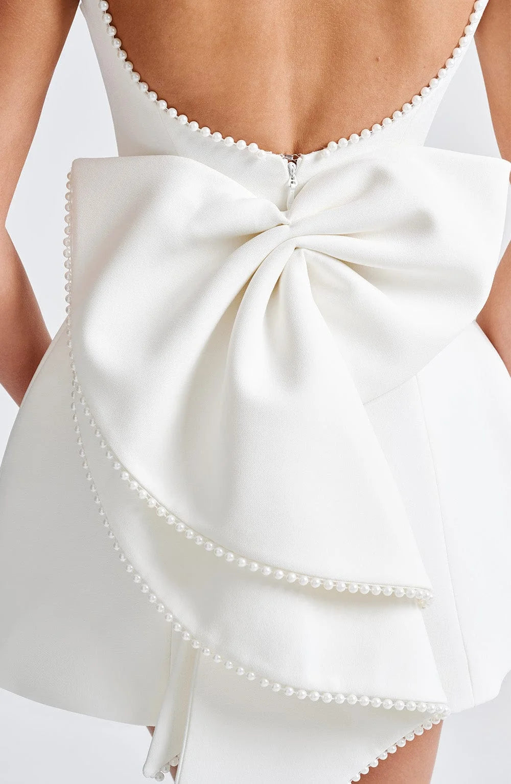 "Black backless dress with pearl accents, perfect for special occasions, made with high-quality fabric."