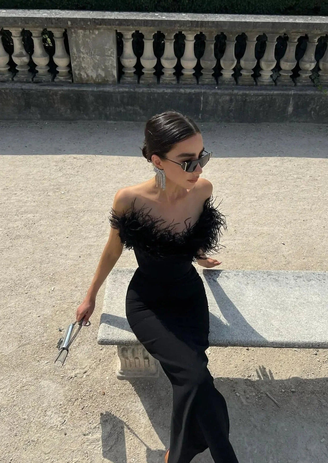 Black strapless dress with feather trim, perfect for special occasions. Elegant design with feather details, offering a…