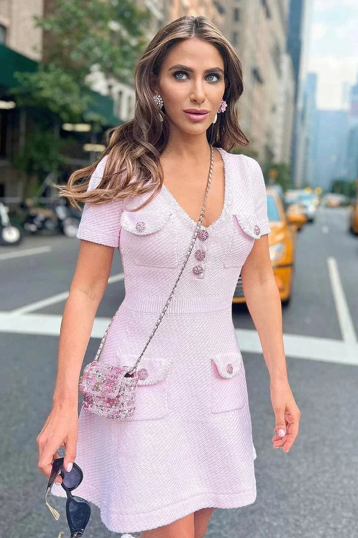 Pink short dress with buttons and pockets made of soft cotton blend fabric, perfect for casual outings or relaxed events.