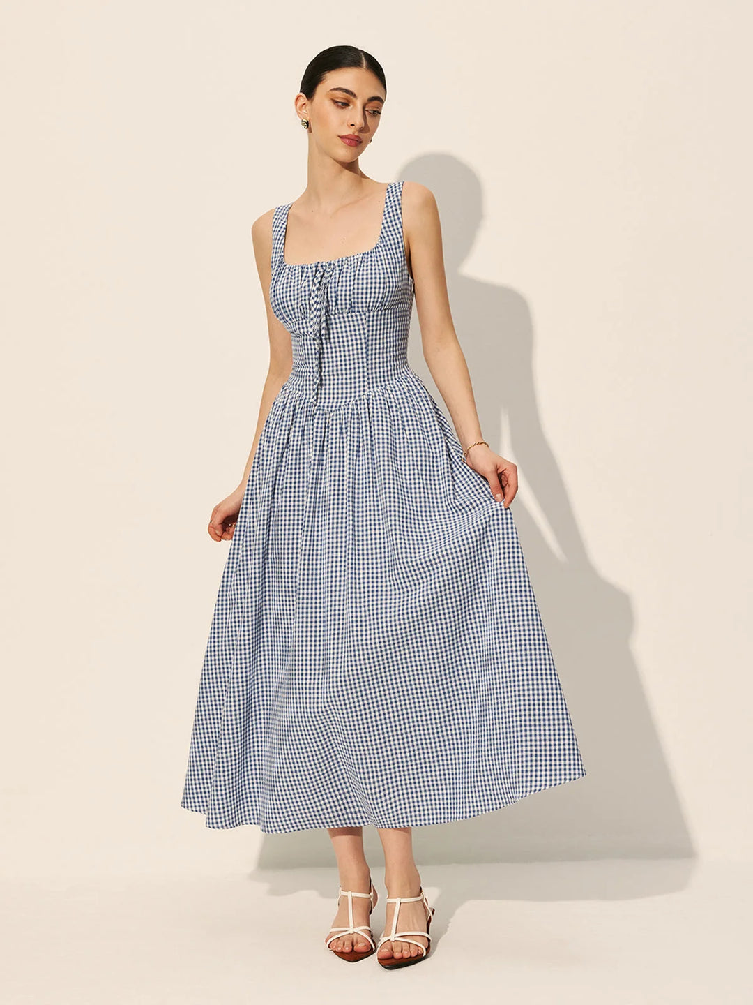 Sleeveless navy gingham cotton maxi dress featuring a classic design with a checkered pattern, ideal for casual and stylish…