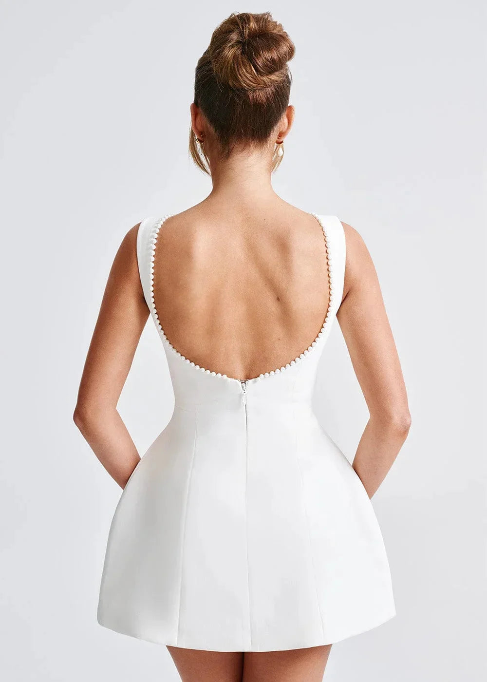 "Black backless mini dress with bow detail, sleek fitted design, perfect for a night out"