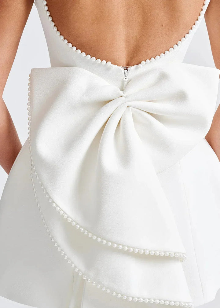 Backless fitted mini dress with bow detail in a sleek and stretchy fabric, perfect for adding a touch of elegance to your…