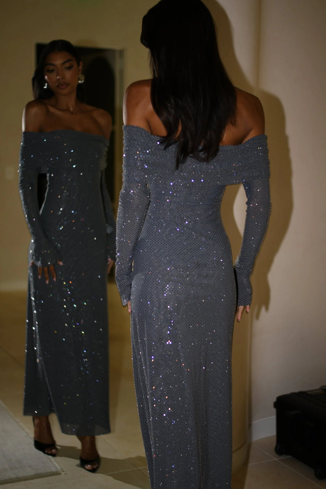 Off-shoulder long glitter dress in shiny silver fabric with a figure-hugging fit and elegant design for a glamorous look.