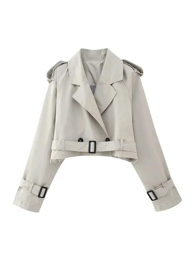 Gray cropped trenchcoat with buckle details, a stylish essential for any wardrobe. Drapes elegantly, perfect for layering in…